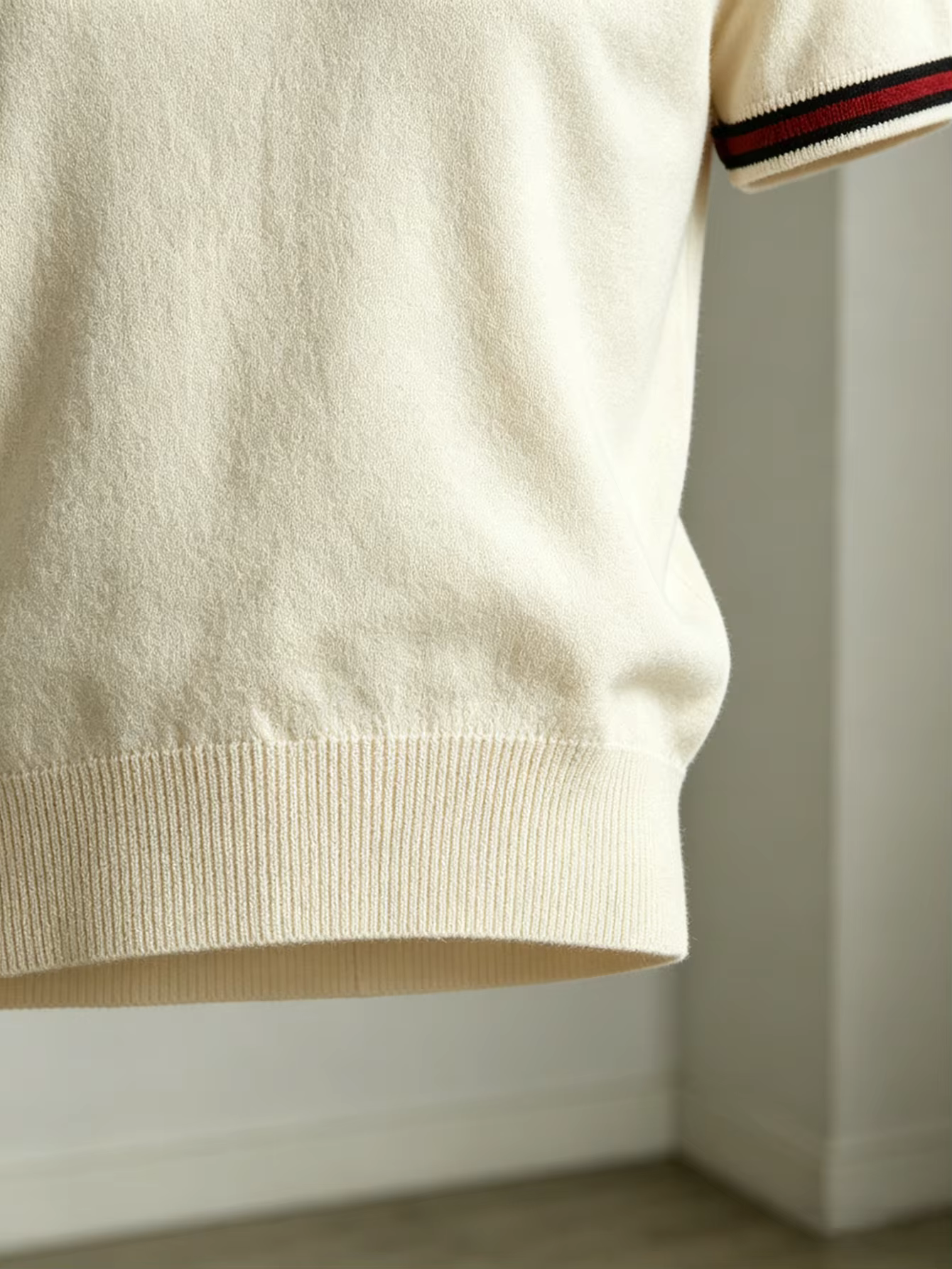 La chemise en tricot à manches courtes de couleur blanc clair convient à porter avec un pantalon